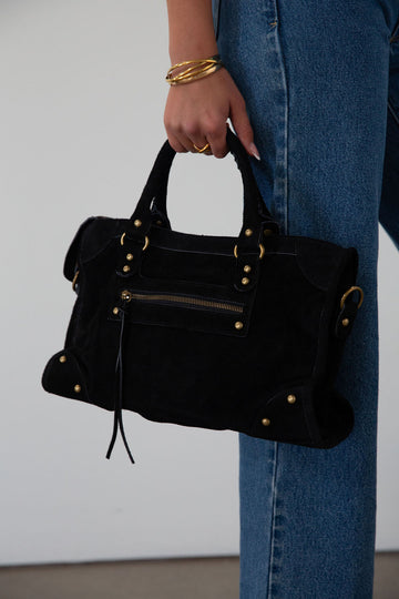 black Suede bag. Adjustable/detachable strap. Fixed top handles. Top zipper closure. Front zipper pocket. Fully lined. Inner pockets and zipper pocket.