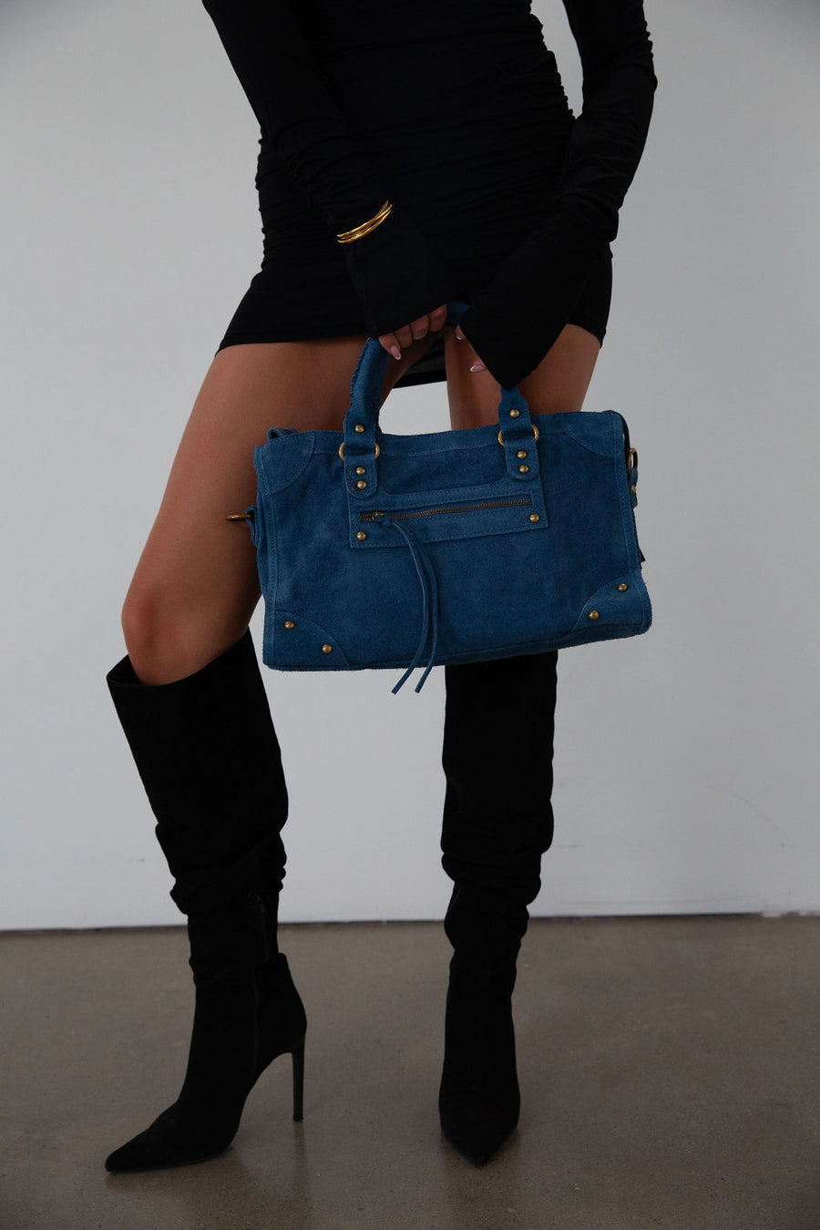 blue Suede bag. Adjustable/detachable strap. Fixed top handles. Top zipper closure. Front zipper pocket. Fully lined. Inner pockets and zipper pocket.