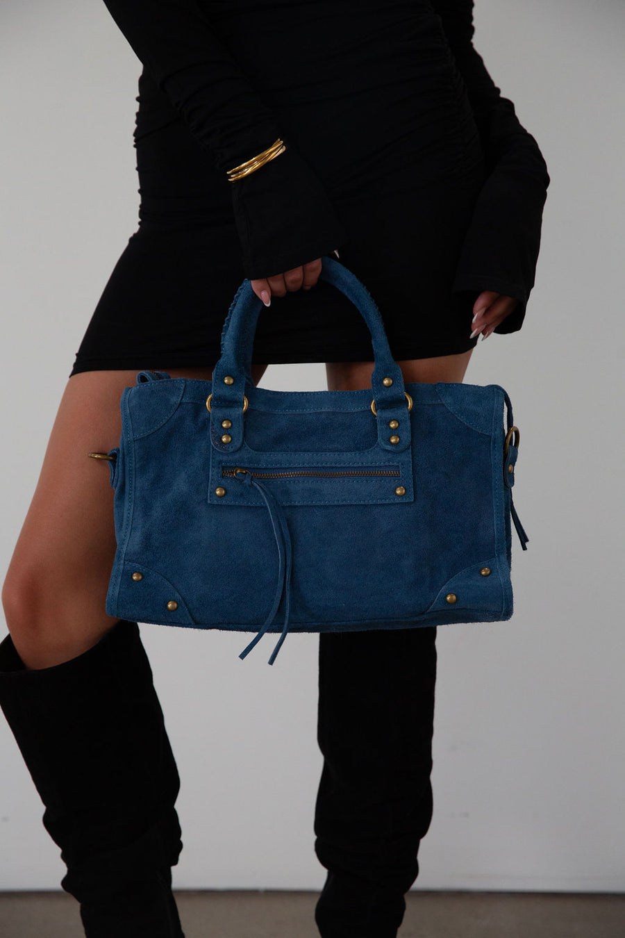 blue Suede bag. Adjustable/detachable strap. Fixed top handles. Top zipper closure. Front zipper pocket. Fully lined. Inner pockets and zipper pocket.