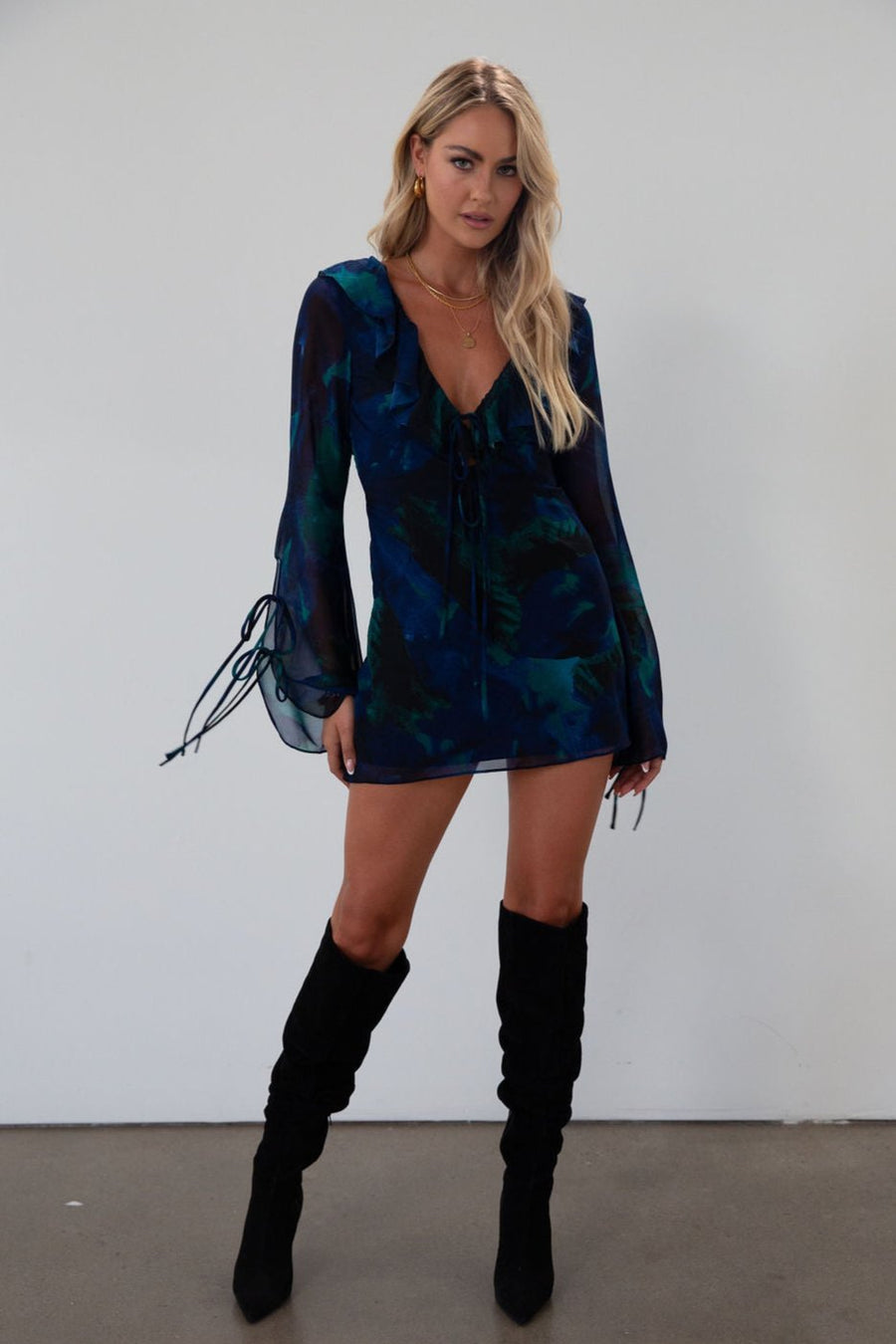 Printed chiffon dress. Long sleeves with tie closures. Ruffle trim. Front and back tie closures. Side zipper closure. Fully lined. mini dress. blue and green mini dress. fall outfit