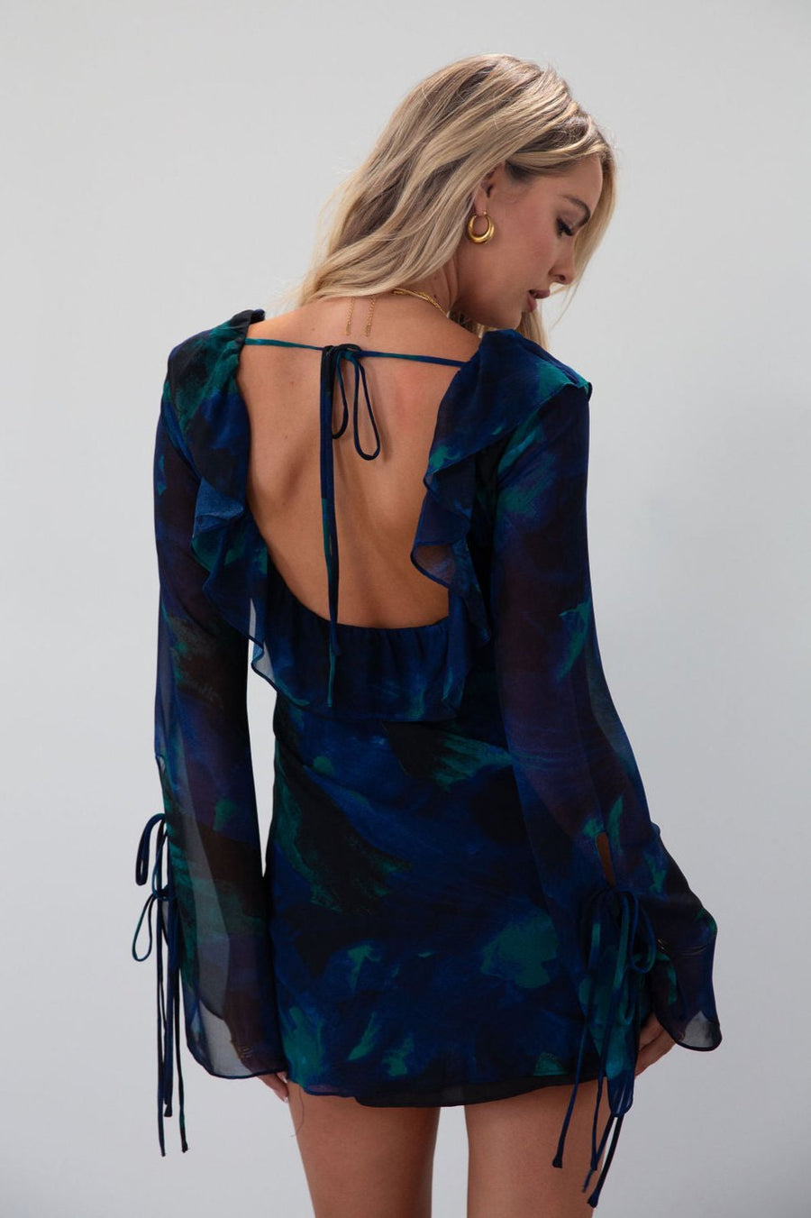 Printed chiffon dress. Long sleeves with tie closures. Ruffle trim. Front and back tie closures. Side zipper closure. Fully lined. mini dress. blue and green mini dress. fall outfit