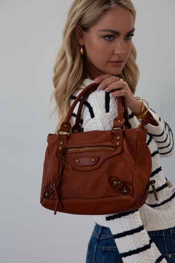 Genuine leather bag. Adjustable/detachable strap. Fixed top handles. Top zipper closure. Front zipper pocket. Fully lined. Inner zipper pocket.