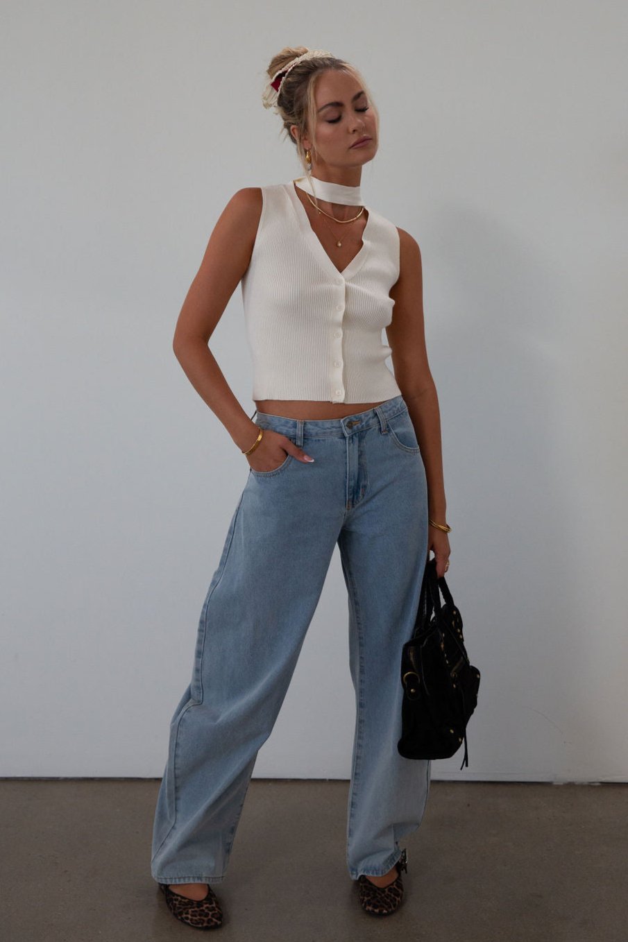 Ribbed knit sleeveless top. V-neckline. Front button down closure. Unlined. Neck tie. white top. white knit vest. fall outfit. fall top. fall transition top.