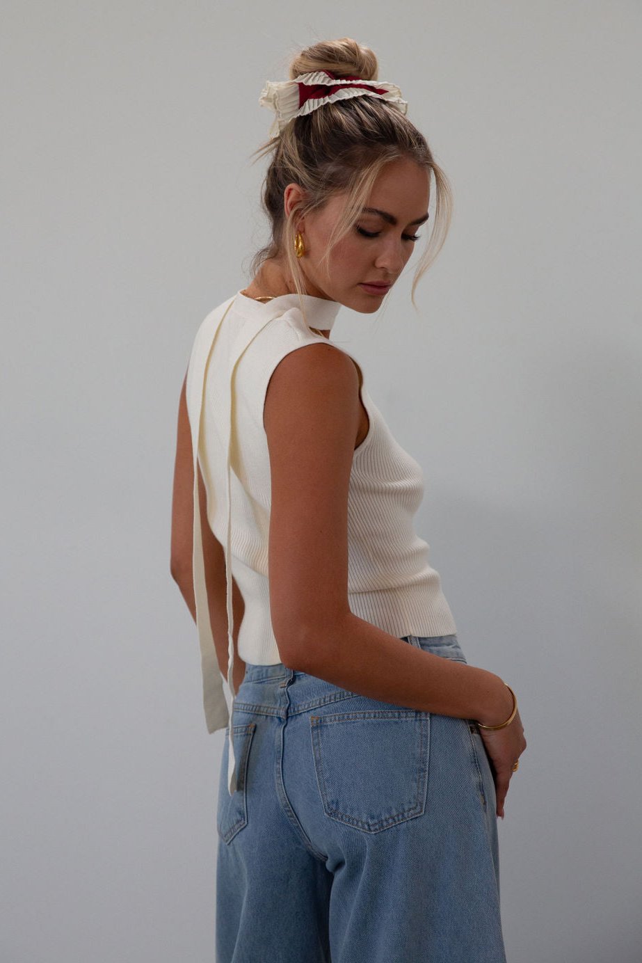 Ribbed knit sleeveless top. V-neckline. Front button down closure. Unlined. Neck tie. white top. white knit vest. fall outfit. fall top. fall transition top.