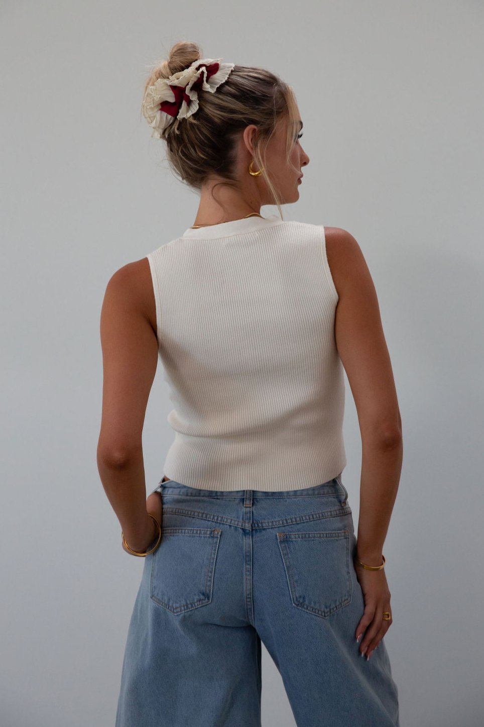 Ribbed knit sleeveless top. V-neckline. Front button down closure. Unlined. Neck tie. white top. white knit vest. fall outfit. fall top. fall transition top.
