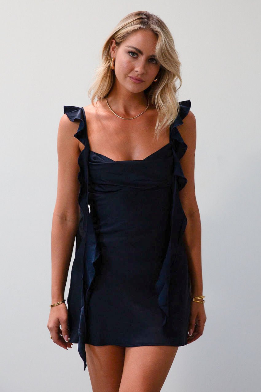 Satin dress. Adjustable straps with ruffle trim. Side hook and eye and zipper closures. Elastic back strap with clasp closure. Fully lined. navy blue mini dress. holiday dress. mini holiday dress