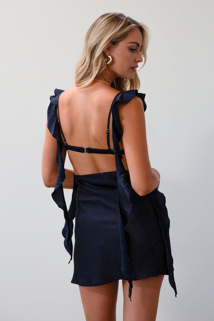 Satin dress. Adjustable straps with ruffle trim. Side hook and eye and zipper closures. Elastic back strap with clasp closure. Fully lined. navy blue mini dress. holiday dress. mini holiday dress