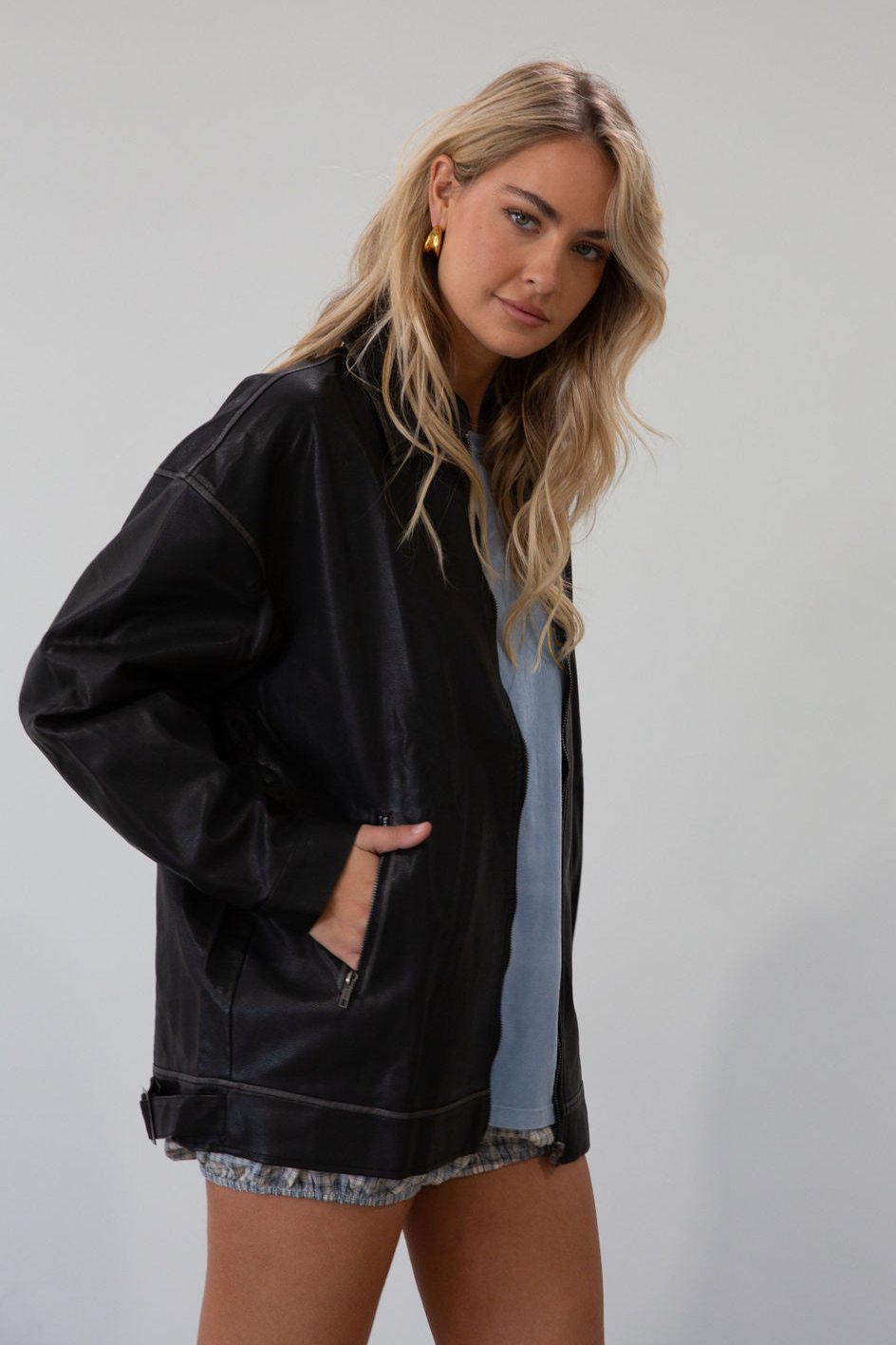 Vegan leather oversized jacket. Collar neckline. Snap button sleeve closures. Exposed front zipper closure. Front pockets with exposed zipper closures. Adjustable sides. Fully lined.&nbsp;