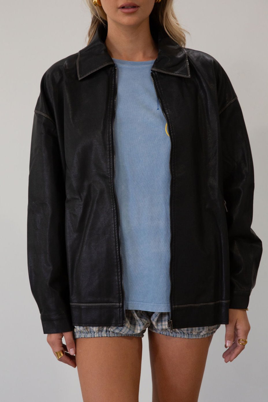 Vegan leather oversized jacket. Collar neckline. Snap button sleeve closures. Exposed front zipper closure. Front pockets with exposed zipper closures. Adjustable sides. Fully lined.&nbsp;