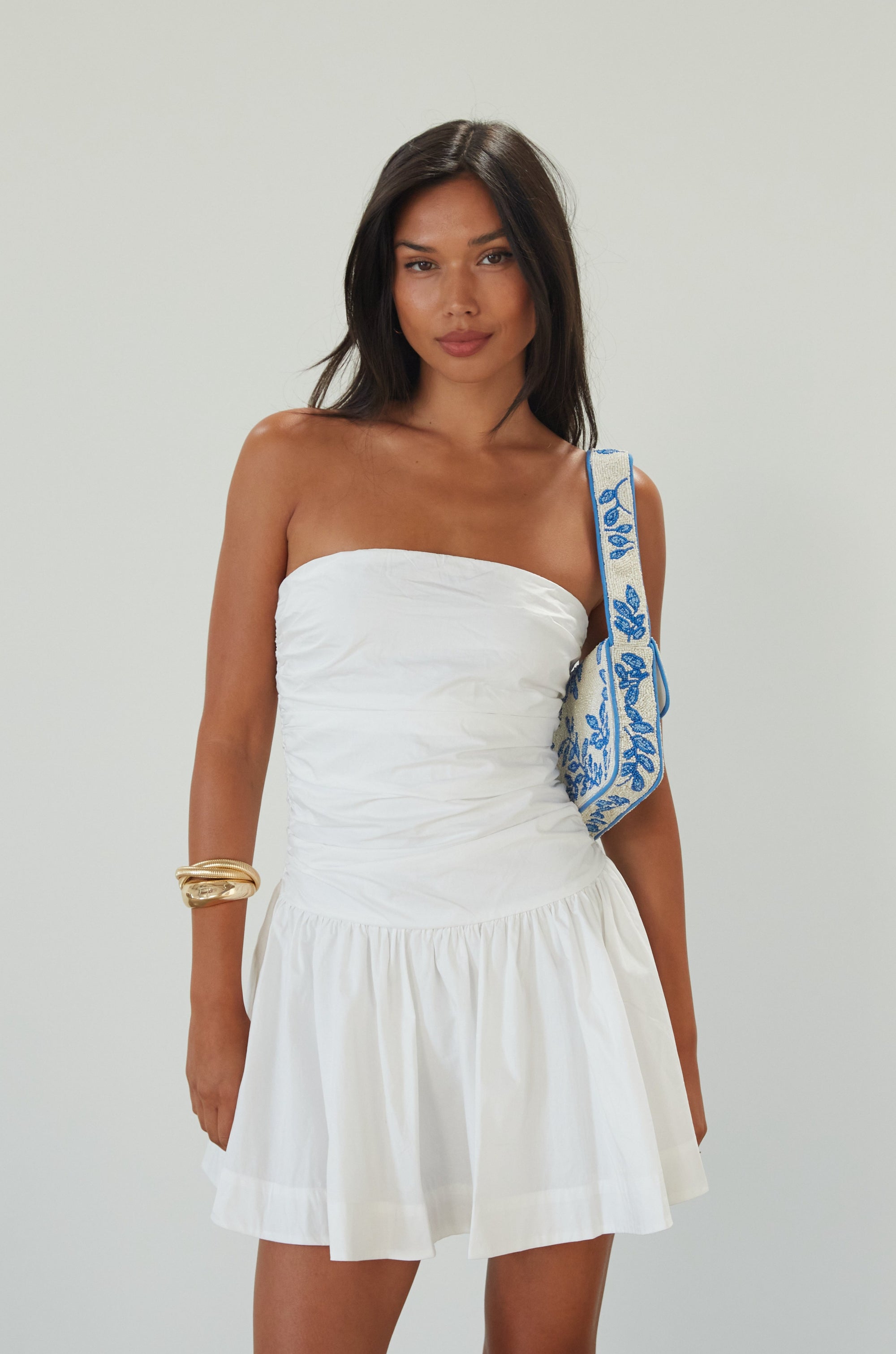 Woven mini dress. Strapless neckline. Inner rubber grip lining. Ruched bodice. Back hook and eye and zipper closure. Fully lined. white mini dress. white strapless mini dress. bridal shower dress. bridal dress. engagement dress. bride outfit. summer dress. fancy dinner dress