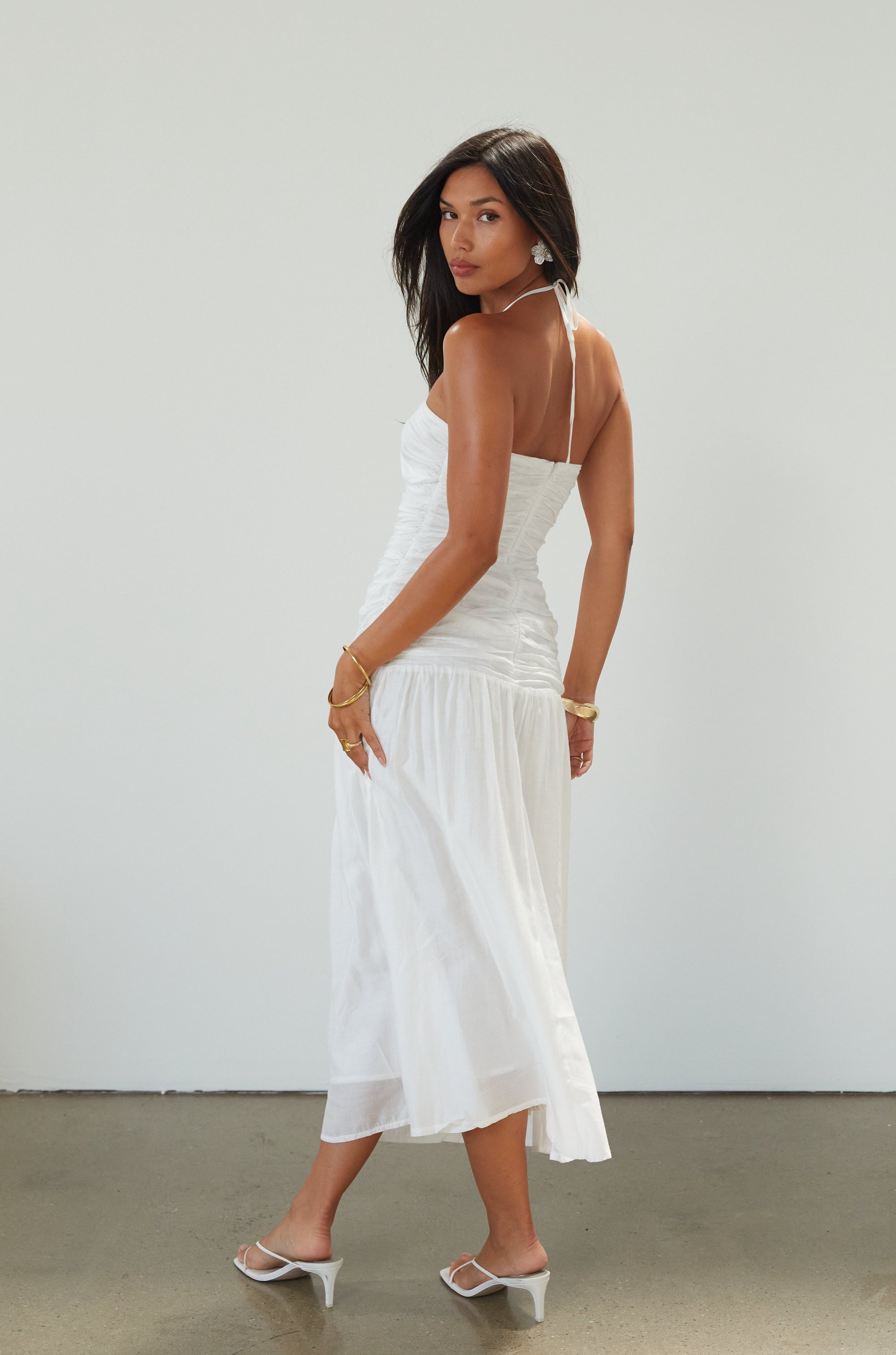 Woven midi dress. Halter tie neckline. Front v-wire. Front cut outs. Ruched bodice. Back hook and eye and zipper closures. Fully lined. Bride. Bridal dress. Engagement dress. Bridal shower dress. summer dress. white midi dress. white halter neck dress