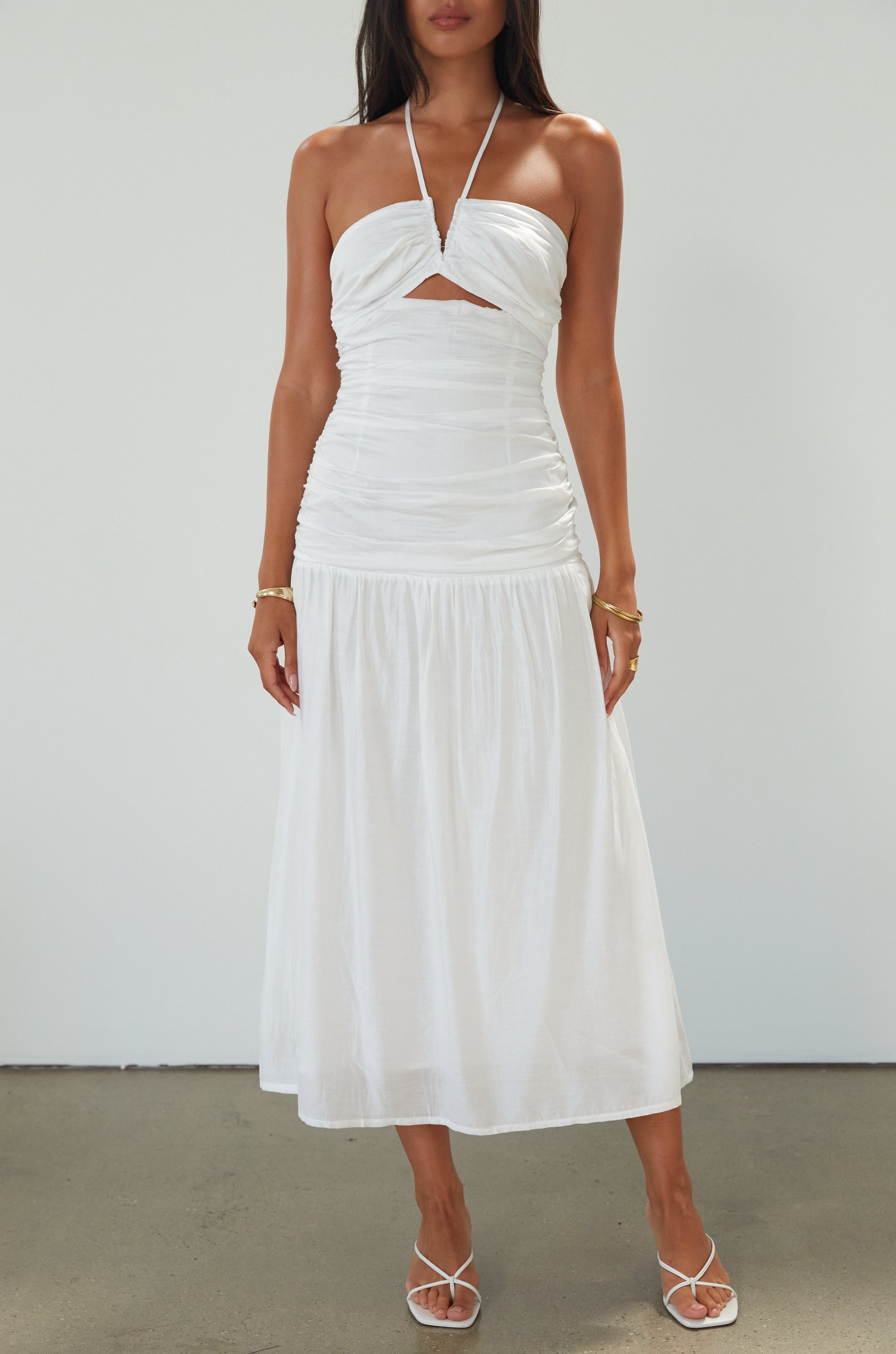 Woven midi dress. Halter tie neckline. Front v-wire. Front cut outs. Ruched bodice. Back hook and eye and zipper closures. Fully lined. Bride. Bridal dress. Engagement dress. Bridal shower dress. summer dress. white midi dress. white halter neck dress