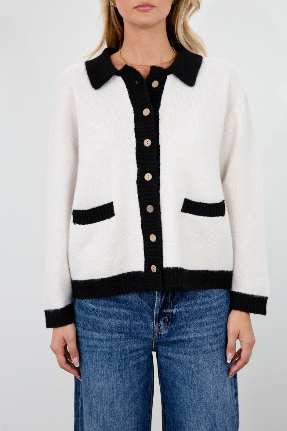 Colorblocked fuzzy crochet knit cardigan. Collar neckline. Front button down closure. Front pockets. Unlined. white cardigan. white and black cardigan. fall sweater. fall outfit. classy cardigan sweater. cardigan sweater
