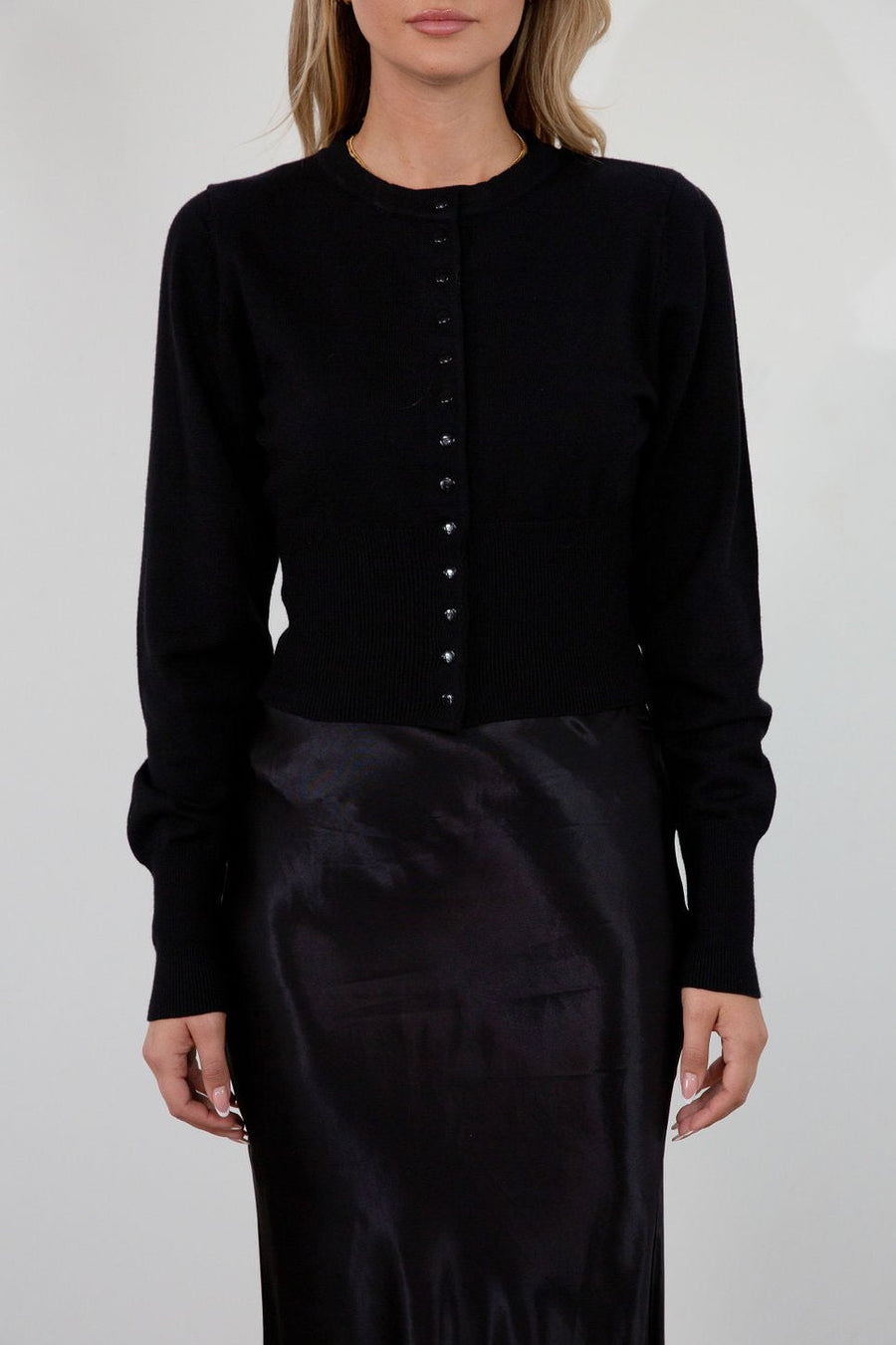 Black knit cardigan. Long sleeves. Front button down closure. Banded hems. Unlined. fall top. fall outfit. holiday outfit.