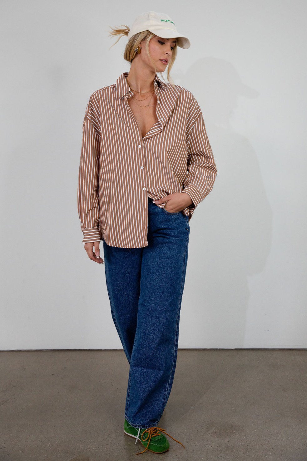 brown and white Striped woven shirt. Collar neckline. Long sleeves with button closures. Front button down closures. Unlined. oversized button down top
