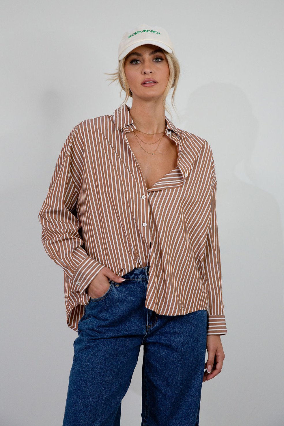 brown and white Striped woven shirt. Collar neckline. Long sleeves with button closures. Front button down closures. Unlined. oversized button down top