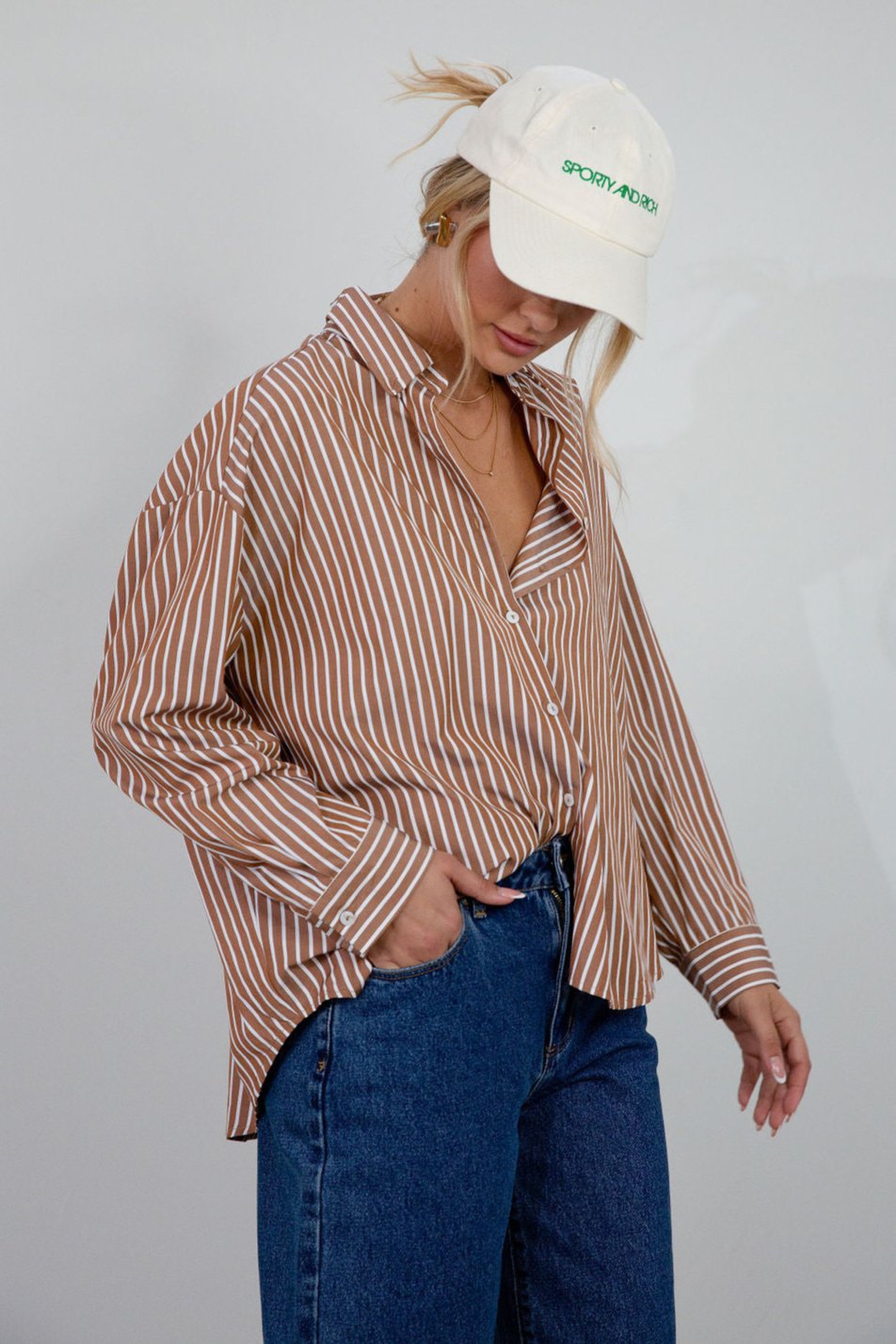 brown and white Striped woven shirt. Collar neckline. Long sleeves with button closures. Front button down closures. Unlined. oversized button down top