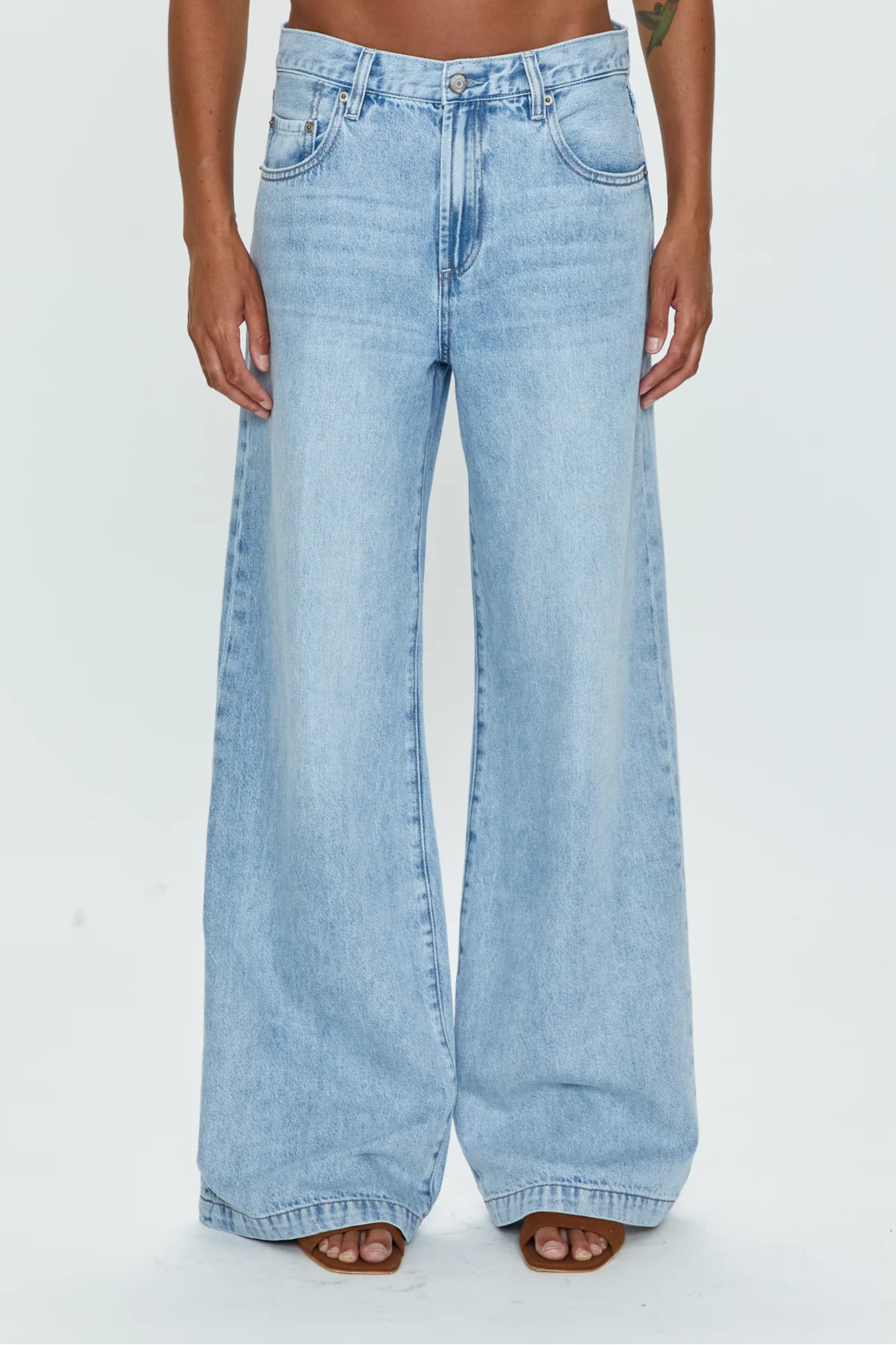 Low slung palazzo jeans. Button and zipper fly. Five pocket construction. Unlined. No stretch. baggy jeans. flare pant. light wash denim jeans