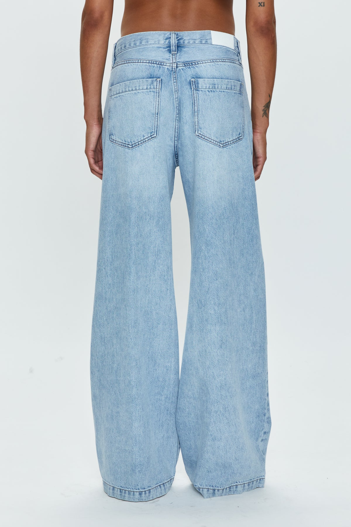 Low slung palazzo jeans. Button and zipper fly. Five pocket construction. Unlined. No stretch. baggy jeans. flare pant. light wash denim jeans