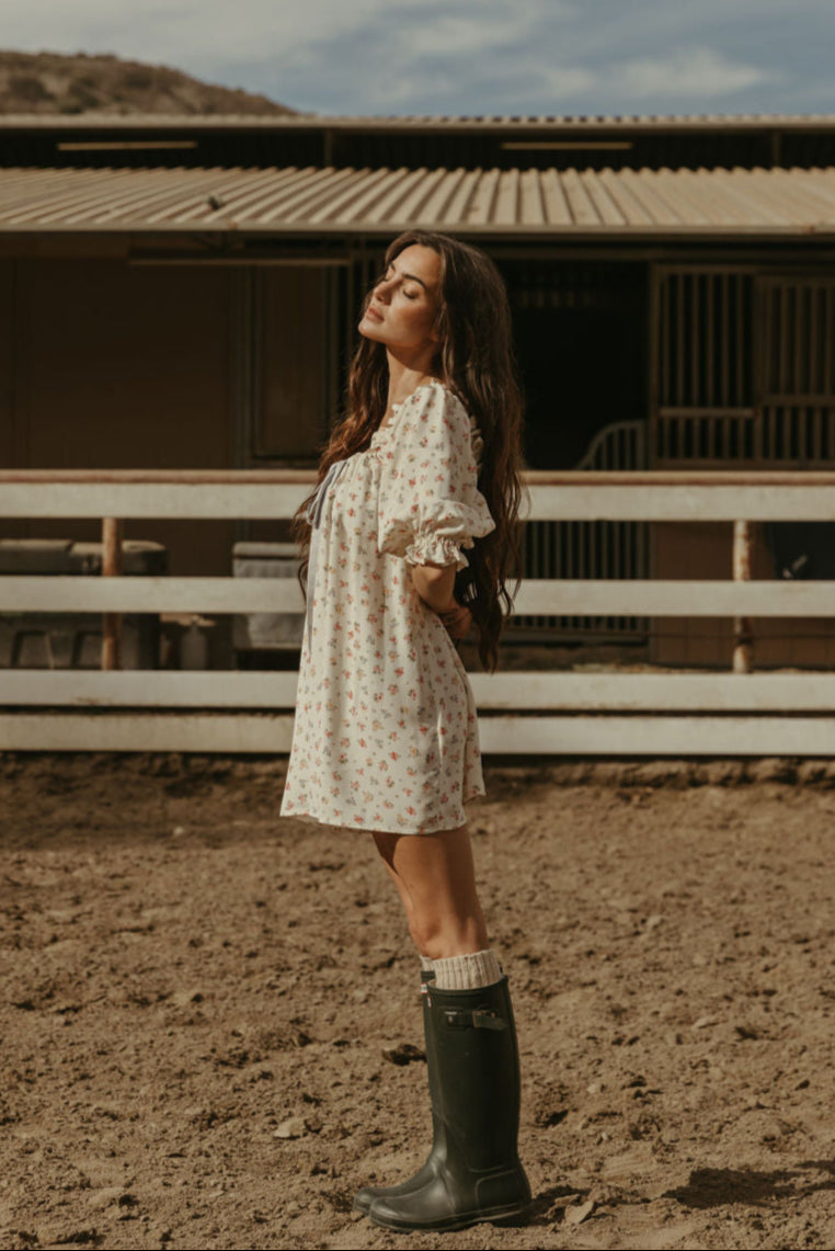 Floral printed woven dress. Elastic neckline. front tie closure. 3/4 sleeves with elastic openings. Unlined. floral mini dress. rumored mini dress. spring mini dress