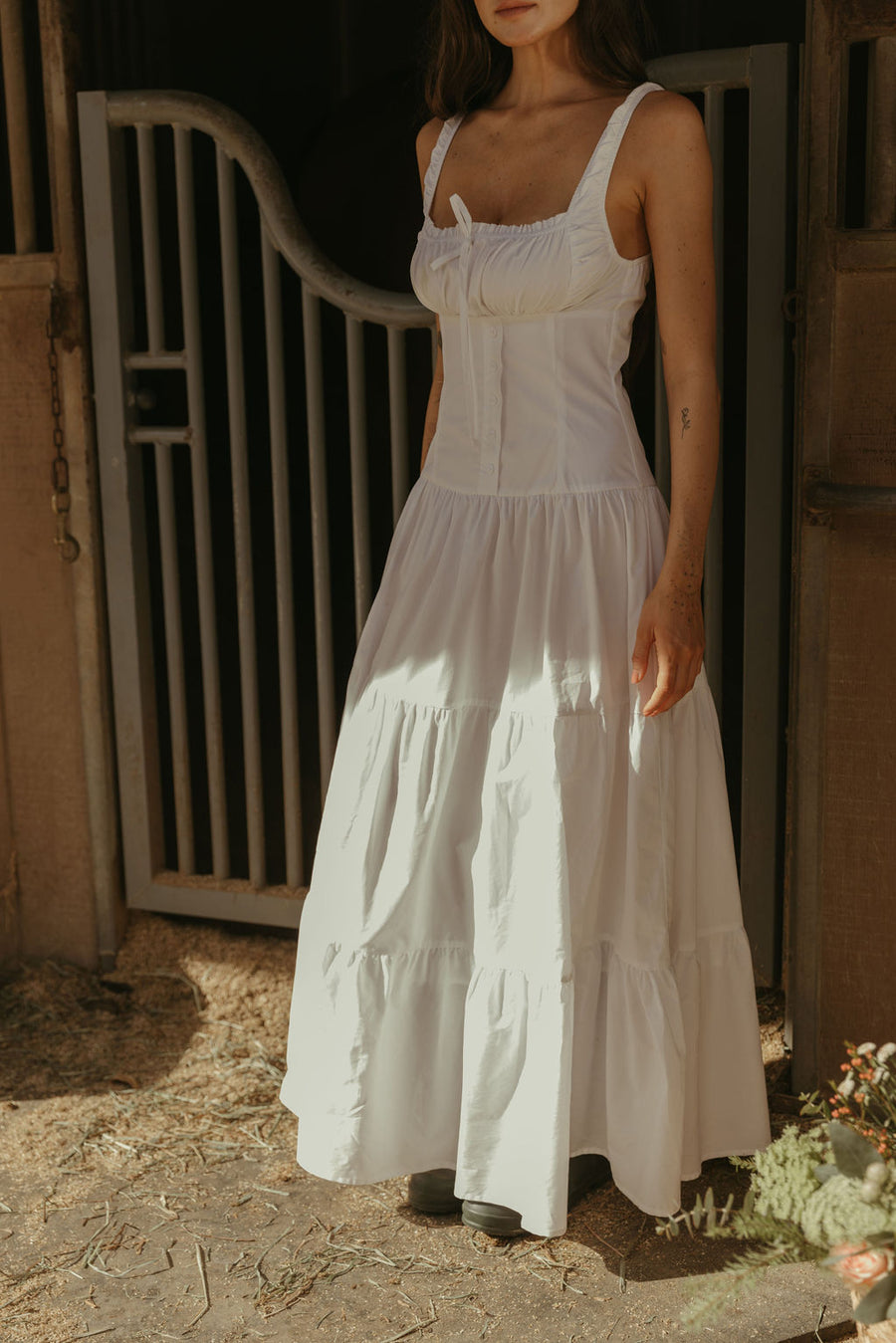 Woven maxi dress. Elastic straps. Faux front tie and button down closures. Tiered skirt. Elastic smocked back panel. Fully lined. white maxi dress