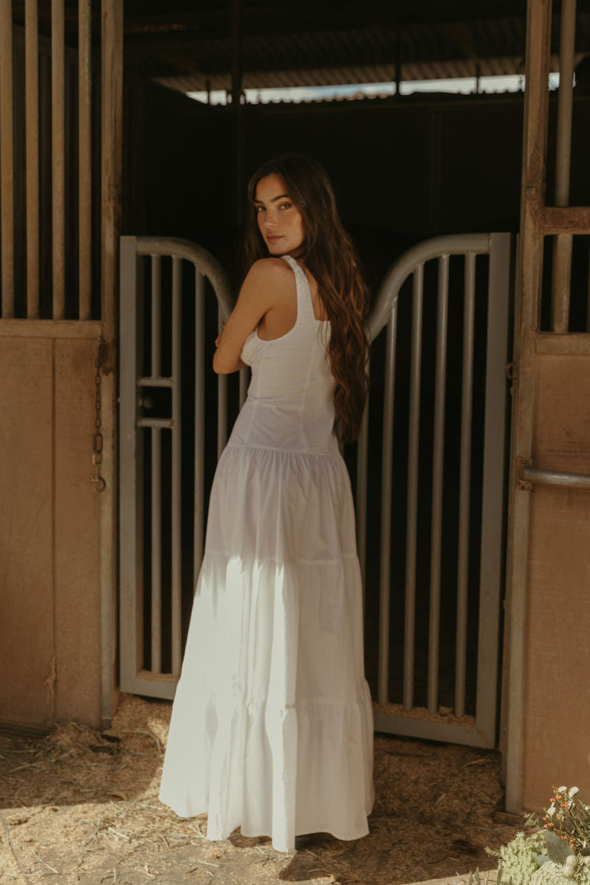 Woven maxi dress. Elastic straps. Faux front tie and button down closures. Tiered skirt. Elastic smocked back panel. Fully lined. white maxi dress