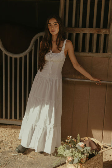 Woven maxi dress. Elastic straps. Faux front tie and button down closures. Tiered skirt. Elastic smocked back panel. Fully lined. white maxi dress