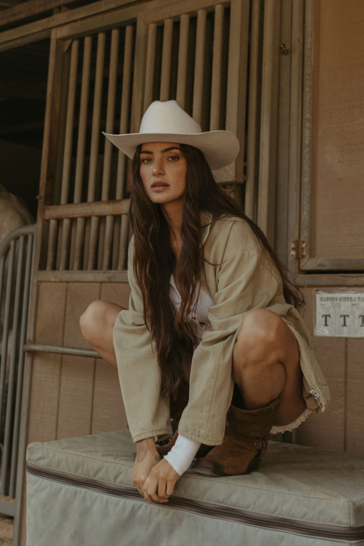 Denim jacket. Collar neckline. Long sleeves. Front zipper closure. Front pockets. Elastic sides. Fully lined. barn jacket. beige barn jacket. ranch shoot